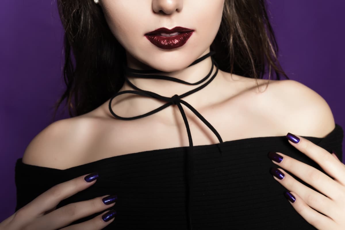 Goth style: black clothing accented with deep crimson, black velvet choker necklace.